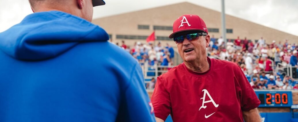 Arkansas coach Dave Van Horn shakes hands with Kansas coach Dan Fitzgerald.