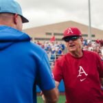 Arkansas coach Dave Van Horn shakes hands with Kansas coach Dan Fitzgerald.