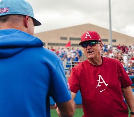 Arkansas coach Dave Van Horn shakes hands with Kansas coach Dan Fitzgerald.